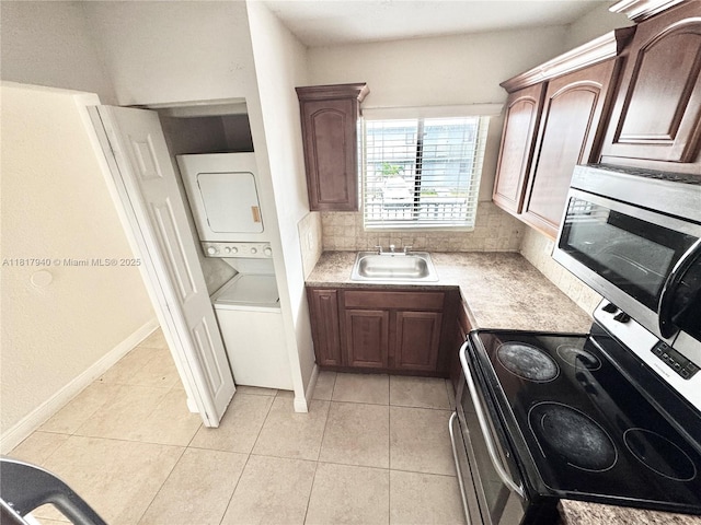 6121 W 24th Ave Unit 204, Hialeah, FL 33016 - kitchen with appliances with stainless steel finishes, stacked washing machine and dryer, a sink, light countertops, and light tile patterned floors