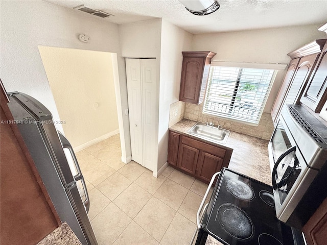 6121 W 24th Ave Unit 204, Hialeah, FL 33016 - kitchen with a sink, light countertops, a textured ceiling, light tile patterned flooring, and backsplash