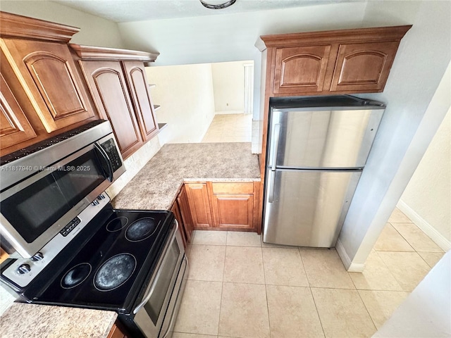 6121 W 24th Ave Unit 204, Hialeah, FL 33016 - kitchen with appliances with stainless steel finishes, light countertops, baseboards, light tile patterned floors, and brown cabinetry