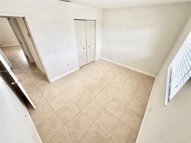 6121 W 24th Ave Unit 204, Hialeah, FL 33016 - unfurnished bedroom with light tile patterned floors, baseboards, and a closet