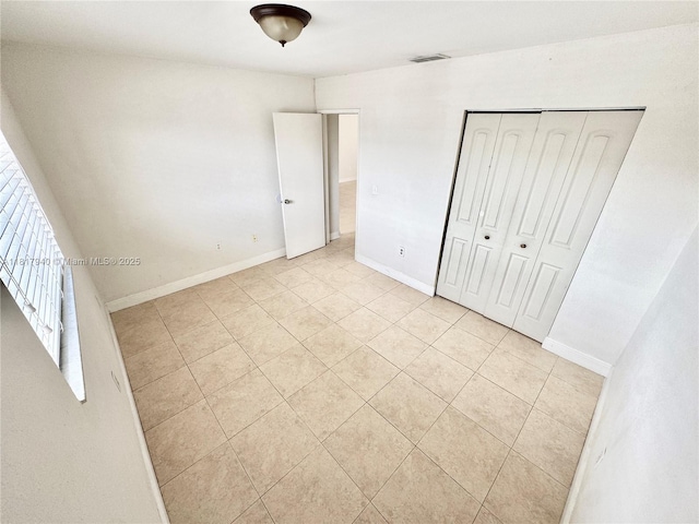 6121 W 24th Ave Unit 204, Hialeah, FL 33016 - unfurnished bedroom featuring light tile patterned flooring, baseboards, and a closet