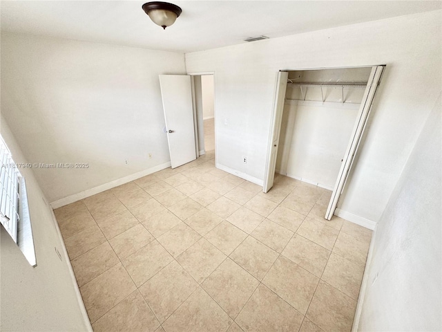 6121 W 24th Ave Unit 204, Hialeah, FL 33016 - unfurnished bedroom featuring light tile patterned floors, a closet, and baseboards