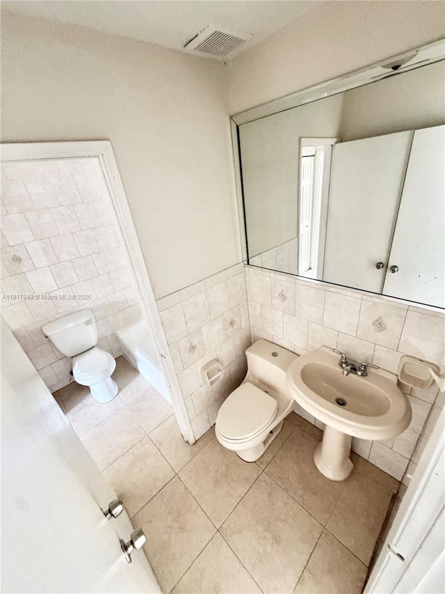 6121 W 24th Ave Unit 204, Hialeah, FL 33016 - full bath featuring tile walls, toilet, tile patterned flooring, a sink, and a bathtub