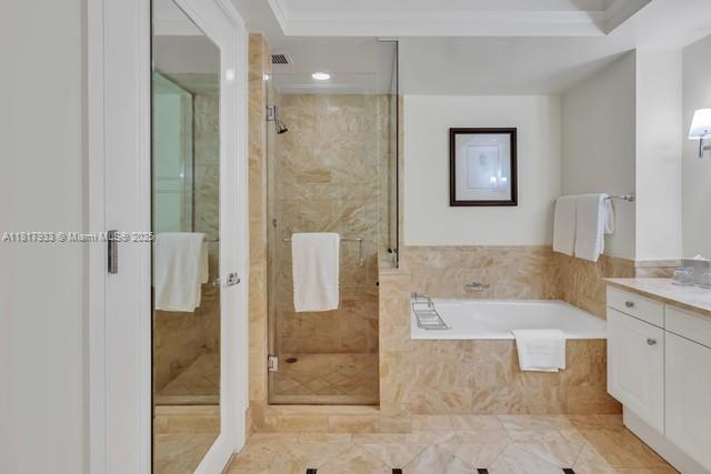 1435 Brickell Ave Unit 3011, Miami, FL 33131 - full bath with vanity, a shower stall, a garden tub, and ornamental molding