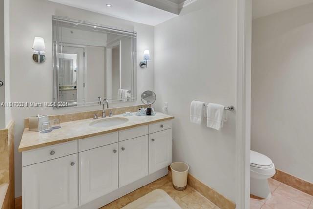 1435 Brickell Ave Unit 3011, Miami, FL 33131 - bathroom featuring vanity, toilet, tile patterned flooring, and baseboards