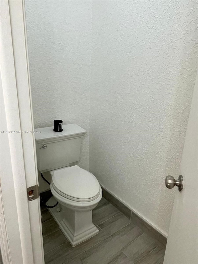 10803 Cypress Glen Dr Unit 10803, Coral Springs, FL 33071 - bathroom with baseboards, toilet, a textured wall, and wood tiled floors