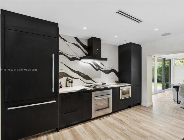 2371 Bayview Ln, North Miami, FL 33181 - kitchen with oven, dark cabinetry, ventilation hood, modern cabinets, and recessed lighting