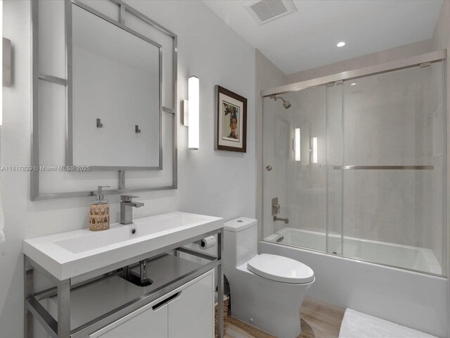 2371 Bayview Ln, North Miami, FL 33181 - full bathroom with toilet, vanity, wood finished floors, enclosed tub / shower combo, and recessed lighting