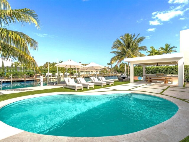 2371 Bayview Ln, North Miami, FL 33181 - outdoor pool featuring a patio, ceiling fan, a water view, an outdoor hangout area, and a dock
