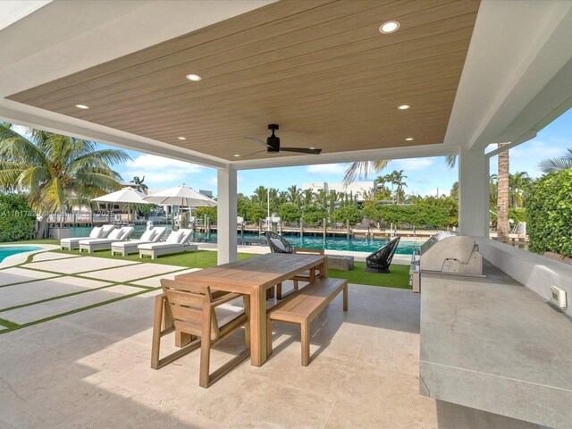 2371 Bayview Ln, North Miami, FL 33181 - view of patio / terrace with area for grilling, an outdoor pool, a ceiling fan, and outdoor dining space