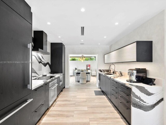 2371 Bayview Ln, North Miami, FL 33181 - kitchen featuring modern cabinets, light wood-style flooring, a sink, recessed lighting, and high quality fridge