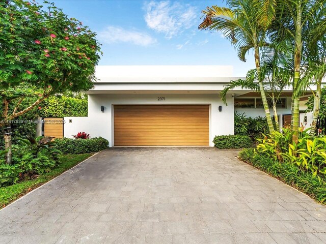 2371 Bayview Ln, North Miami, FL 33181 - view of front facade featuring stucco siding, an attached garage, and asphalt driveway
