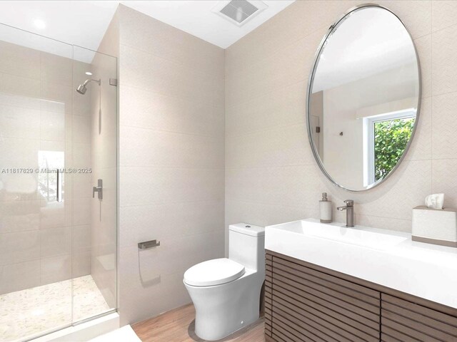 2371 Bayview Ln, North Miami, FL 33181 - full bath featuring a shower stall, wood finished floors, vanity, toilet, and tile walls