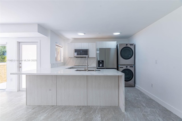 13900 SW 65th Ter Unit 9, Miami, FL 33183 - kitchen with stainless steel appliances, stacked washer / dryer, light countertops, a peninsula, and recessed lighting