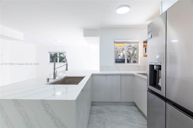 13900 SW 65th Ter Unit 9, Miami, FL 33183 - kitchen featuring stainless steel fridge with ice dispenser, a sink, modern cabinets, light stone countertops, and a peninsula