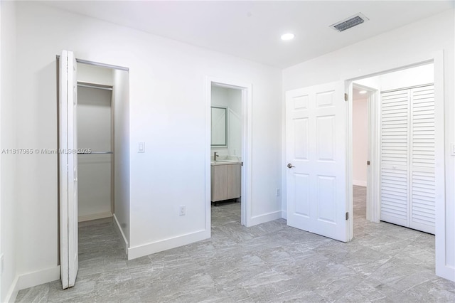 13900 SW 65th Ter Unit 9, Miami, FL 33183 - unfurnished bedroom featuring a walk in closet, a sink, a closet, baseboards, and recessed lighting