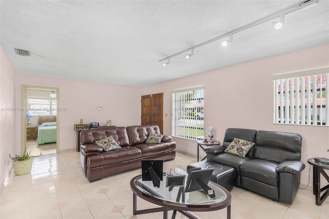 10845 SW 26th Ter, Miami, FL 33165 - living room with healthy amount of natural light, a textured ceiling, and light tile patterned floors