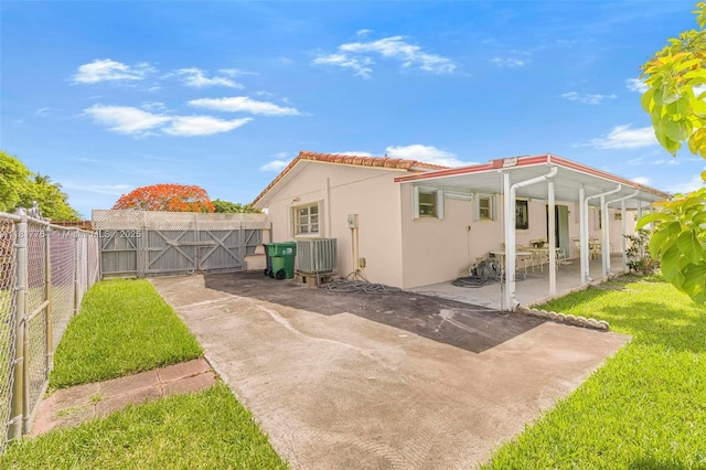 10845 SW 26th Ter, Miami, FL 33165 - rear view of house with a patio area, stucco siding, a fenced backyard, a tiled roof, and a gate