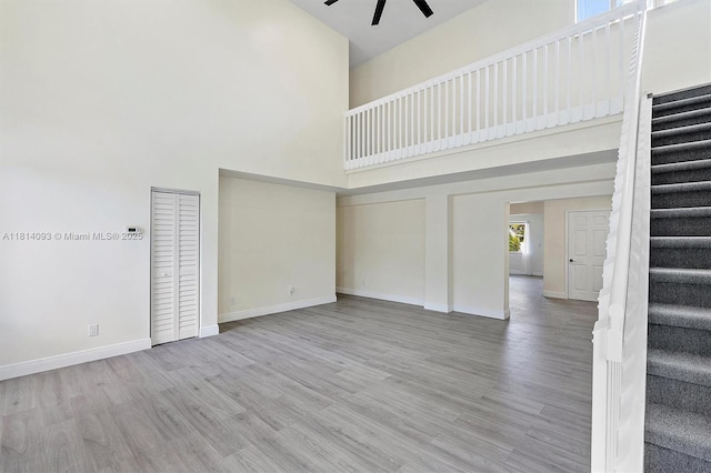 6221 NW 37th Ter, Virginia Gardens, FL 33166 - unfurnished living room with a high ceiling, stairway, a ceiling fan, and wood finished floors