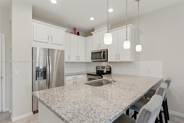 2200 Garden Belle Dr, Clermont, FL 34711 - kitchen with stainless steel appliances, a sink, a peninsula, a breakfast bar area, and baseboards