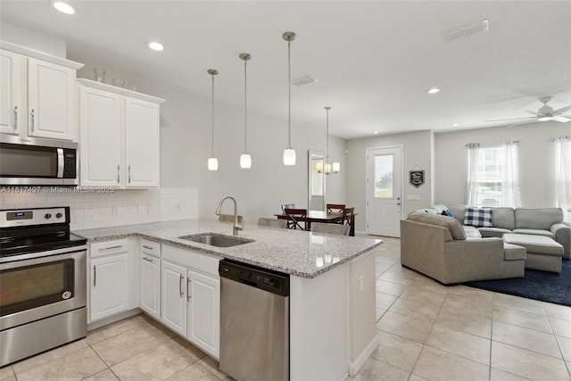2200 Garden Belle Dr, Clermont, FL 34711 - kitchen with stainless steel appliances, a sink, a peninsula, light tile patterned floors, and recessed lighting