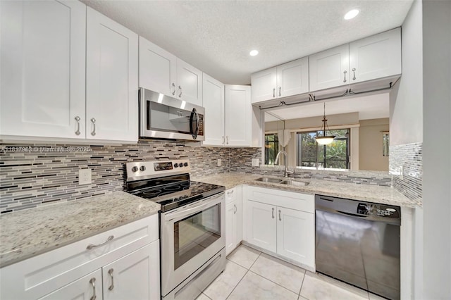 1615 N 14th Ter, Hollywood, FL 33020 - kitchen featuring stainless steel appliances, a sink, white cabinetry, light tile patterned floors, and decorative backsplash