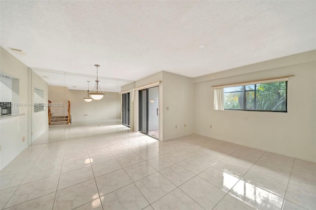 1615 N 14th Ter, Hollywood, FL 33020 - empty room with stairs, light tile patterned floors, and a textured ceiling