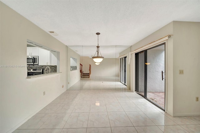 1615 N 14th Ter, Hollywood, FL 33020 - hallway featuring stairway, light tile patterned floors, and a textured ceiling
