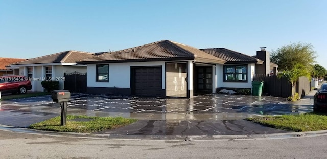 14880 SW 56th Ter, Miami, FL 33193 - view of front of house with a garage, a tiled roof, stucco siding, and french doors