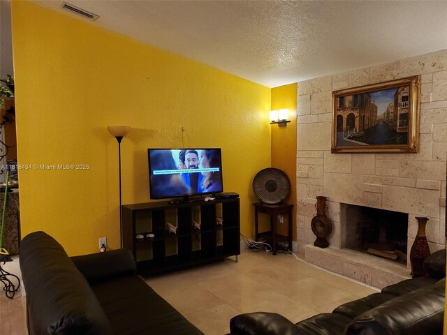 14880 SW 56th Ter, Miami, FL 33193 - living area with a textured ceiling, a stone fireplace, and tile patterned flooring