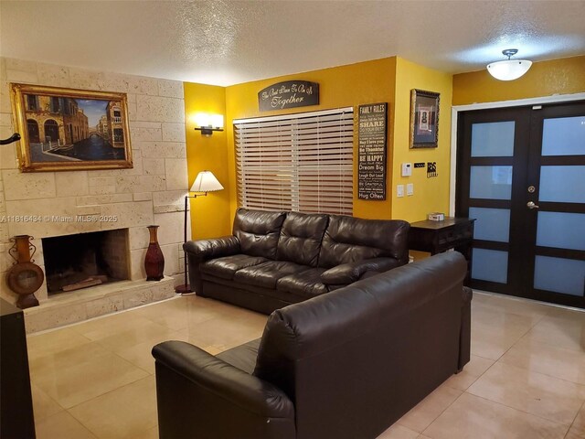 14880 SW 56th Ter, Miami, FL 33193 - living room with a textured ceiling, light tile patterned floors, french doors, and a large fireplace