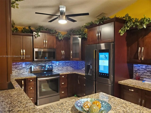 14880 SW 56th Ter, Miami, FL 33193 - kitchen with appliances with stainless steel finishes, decorative backsplash, light stone counters, ceiling fan, and glass insert cabinets