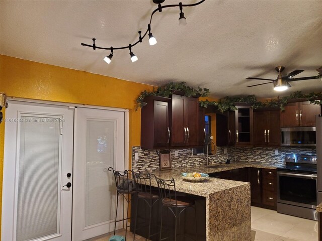 14880 SW 56th Ter, Miami, FL 33193 - kitchen with appliances with stainless steel finishes, a sink, backsplash, a peninsula, and ceiling fan