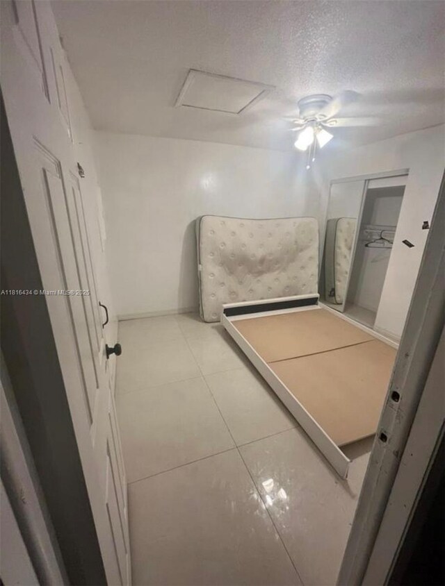 14880 SW 56th Ter, Miami, FL 33193 - unfurnished bedroom with tile patterned floors, a textured ceiling, ceiling fan, and attic access