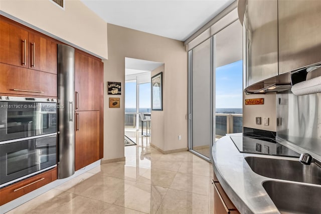18101 Collins Ave Unit 5401, Sunny Isles Beach, FL 33160 - kitchen with brown cabinetry, a sink, and light tile patterned floors