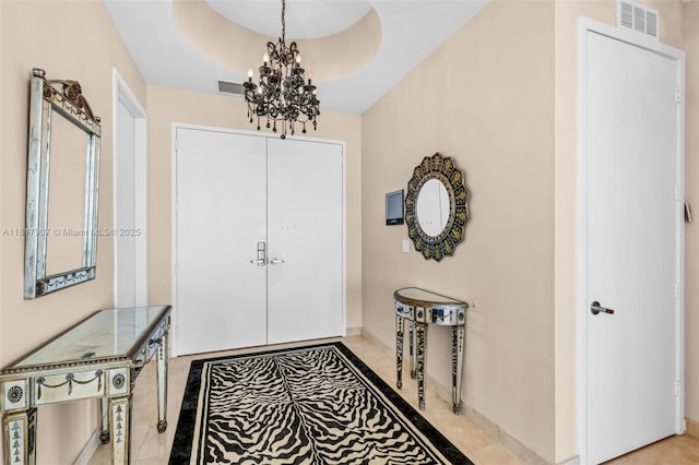 18101 Collins Ave Unit 5401, Sunny Isles Beach, FL 33160 - foyer entrance with inlaid floor details, a chandelier, baseboards, and a tray ceiling