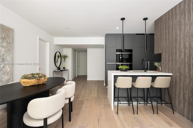 200 Sunrise Dr Unit 200A, Key Biscayne, FL 33149 - kitchen featuring modern cabinets, a kitchen bar, a peninsula, light wood finished floors, and double oven