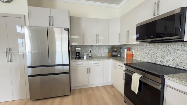 4221 Laurel Ridge Cir, Weston, FL 33331 - kitchen with appliances with stainless steel finishes, ornamental molding, backsplash, light wood finished floors, and light stone counters
