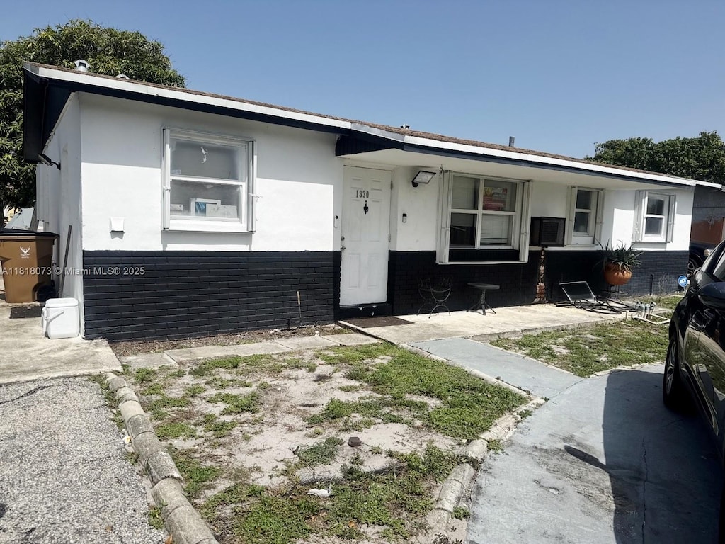 1330 SW 6th Ter, Deerfield Beach, FL 33441 - view of front of home with a porch, brick siding, and stucco siding