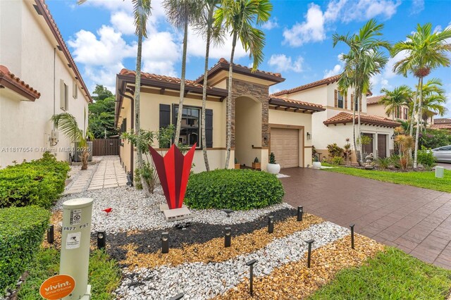 685 SE 34th Ter, Homestead, FL 33033 - mediterranean / spanish-style house with an attached garage, stucco siding, driveway, and a tiled roof