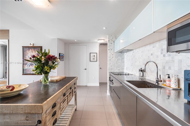 1040 Biscayne Blvd Unit 3607, Miami, FL 33132 - kitchen featuring a sink, stainless steel microwave, tasteful backsplash, and white cabinetry