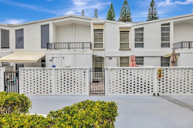 2730 NE 183rd St Unit Th03, Aventura, FL 33160 - view of property with a fenced front yard, stucco siding, a gate, and a balcony