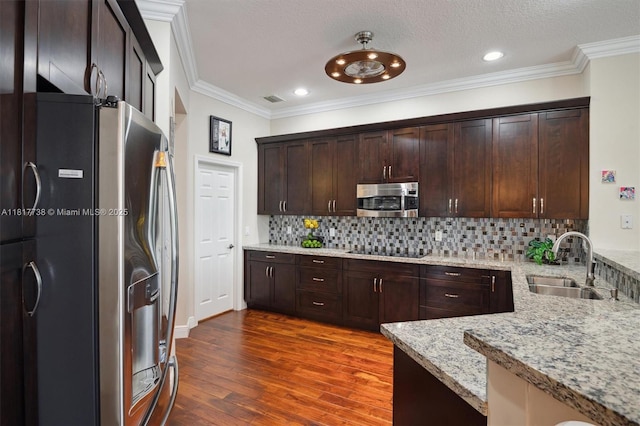 13357 SW 42nd St, Davie, FL 33330 - kitchen featuring appliances with stainless steel finishes, a sink, dark wood finished floors, crown molding, and light stone countertops