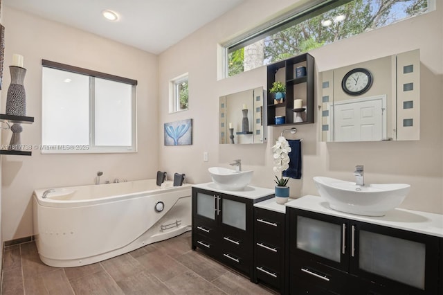13357 SW 42nd St, Davie, FL 33330 - bathroom with two vanities, a bath, and wood finished floors