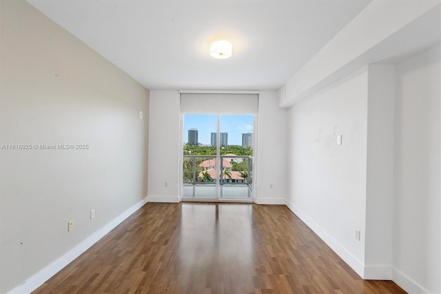 3030 NE 188th St Unit 609, Aventura, FL 33180 - unfurnished room with baseboards, wood finished floors, and expansive windows
