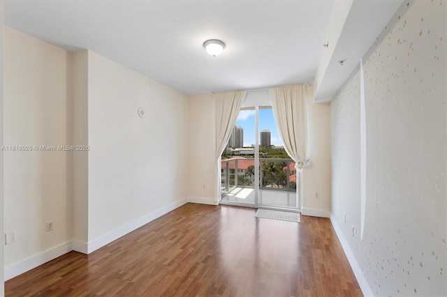 3030 NE 188th St Unit 609, Aventura, FL 33180 - empty room with wood finished floors, baseboards, and a city view