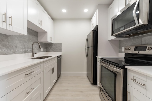 13255 SW 7th Ct Unit 303D, Pembroke Pines, FL 33027 - kitchen with appliances with stainless steel finishes, a sink, tasteful backsplash, light wood finished floors, and white cabinets
