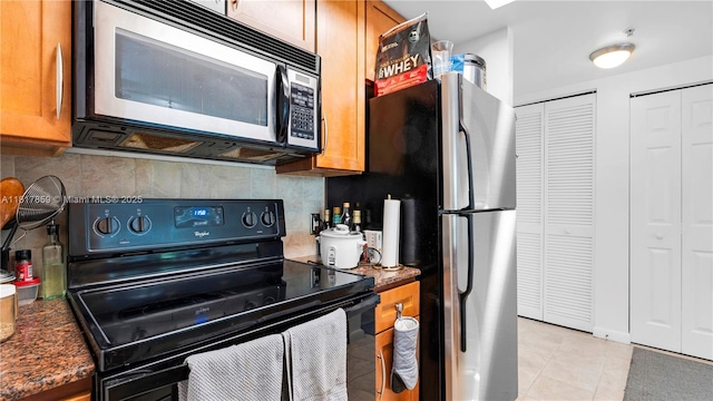 2000 N Bayshore Dr Unit 218, Miami, FL 33137 - kitchen featuring black range with electric cooktop, tasteful backsplash, brown cabinetry, and light tile patterned floors