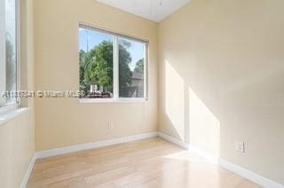 1416 N 2nd Ave N, Lake Worth, FL 33460 - unfurnished room featuring lofted ceiling, light wood-style floors, and baseboards
