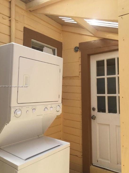 1416 N 2nd Ave N, Lake Worth, FL 33460 - laundry room featuring stacked washer / dryer and wood walls